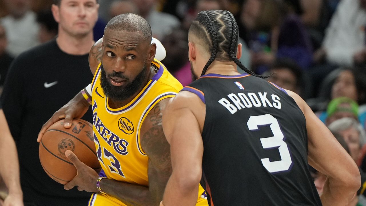 Los Angeles Lakers forward Lebron James squares up to Phoenix Suns forward Dillon Brooks (3) during the first half of an NBA basketball game, Tuesday, Dec. 23, 2025, in Phoenix. (AP Photo/Rick Scuteri)