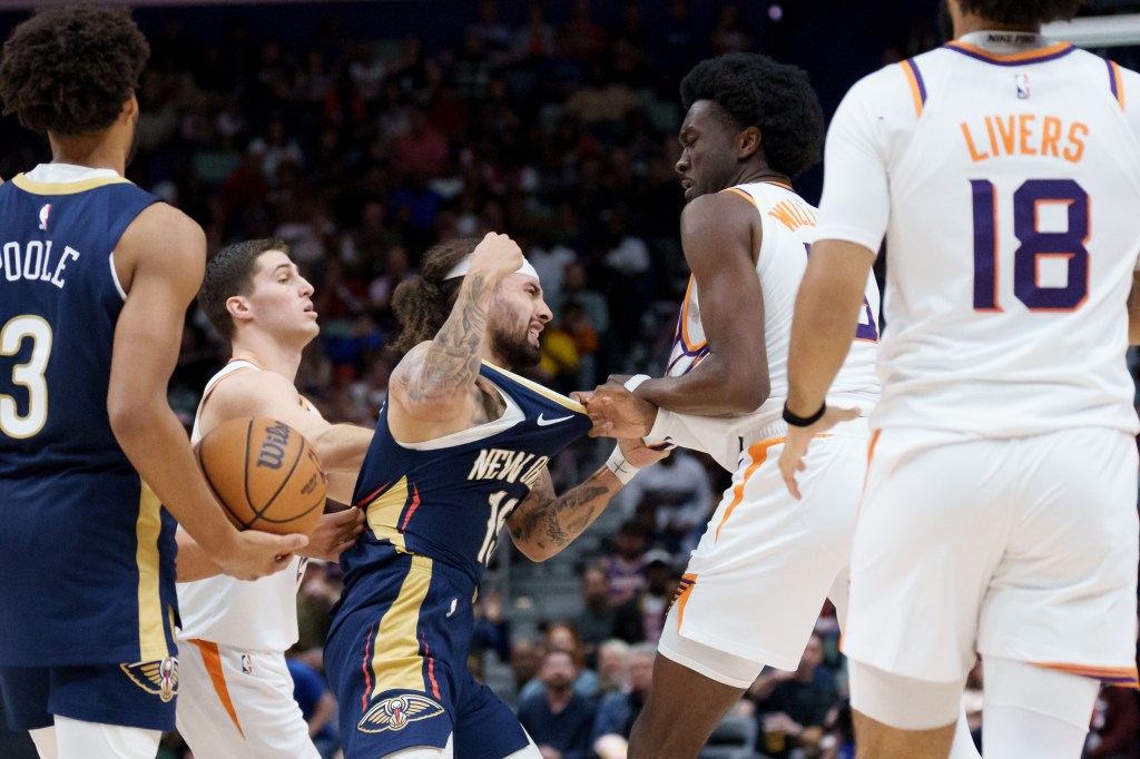 New Orleans Pelicans guard Jose Alvarado and Phoenix Suns center Mark Williams getting into a scrum during a basketball game.