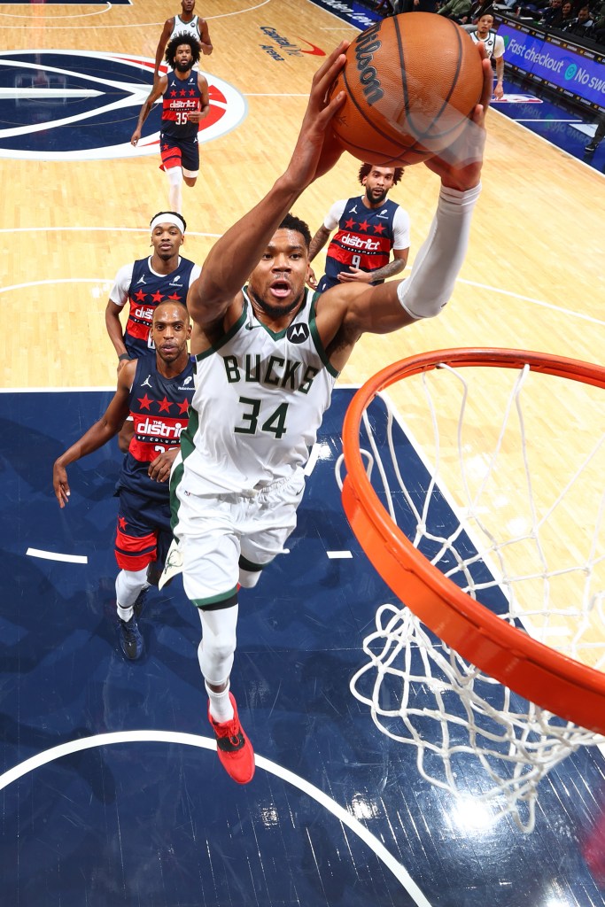 Giannis Antetokounmpo dunks the ball during a basketball game.