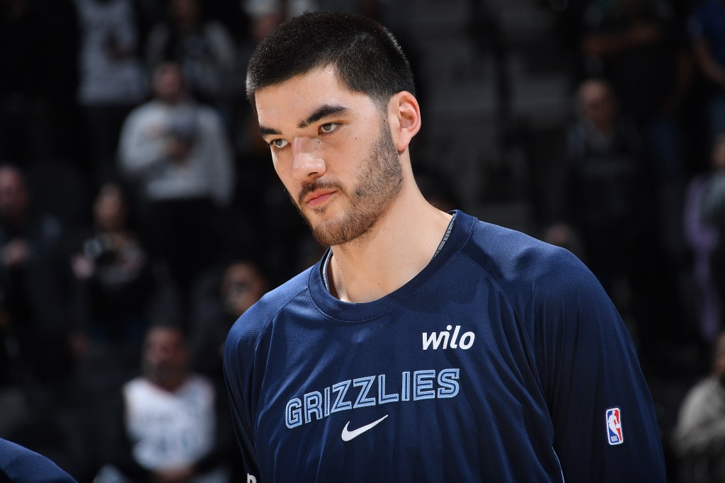 Zach Edey of the Memphis Grizzlies in a navy shirt looking on.