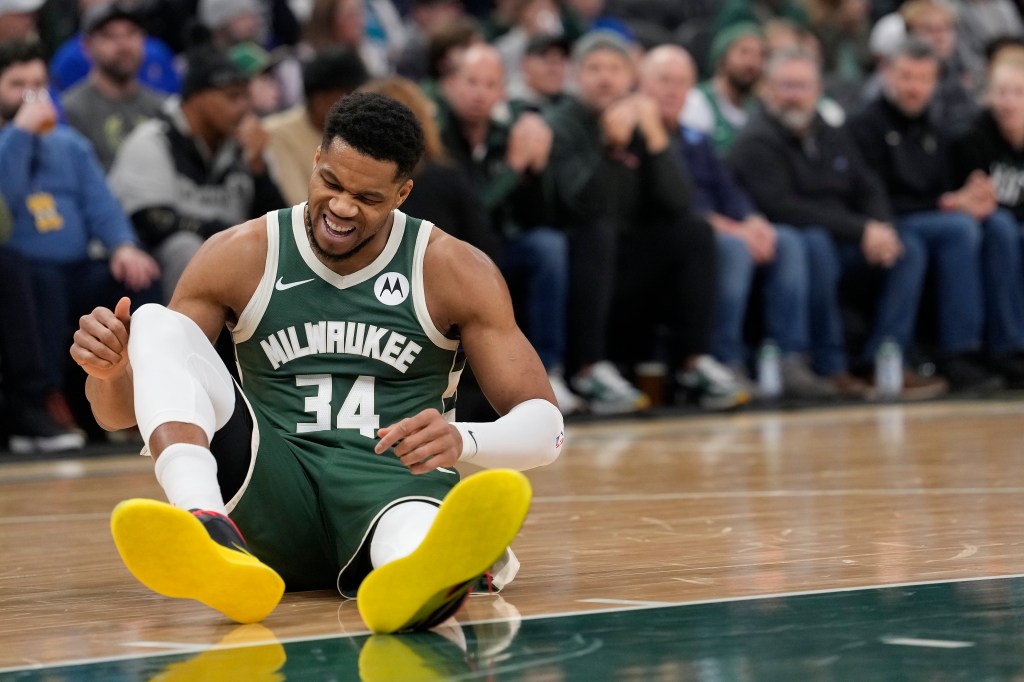 Giannis Antetokounmpo of the Milwaukee Bucks reacting to an apparent injury on the court during a game against the Detroit Pistons.