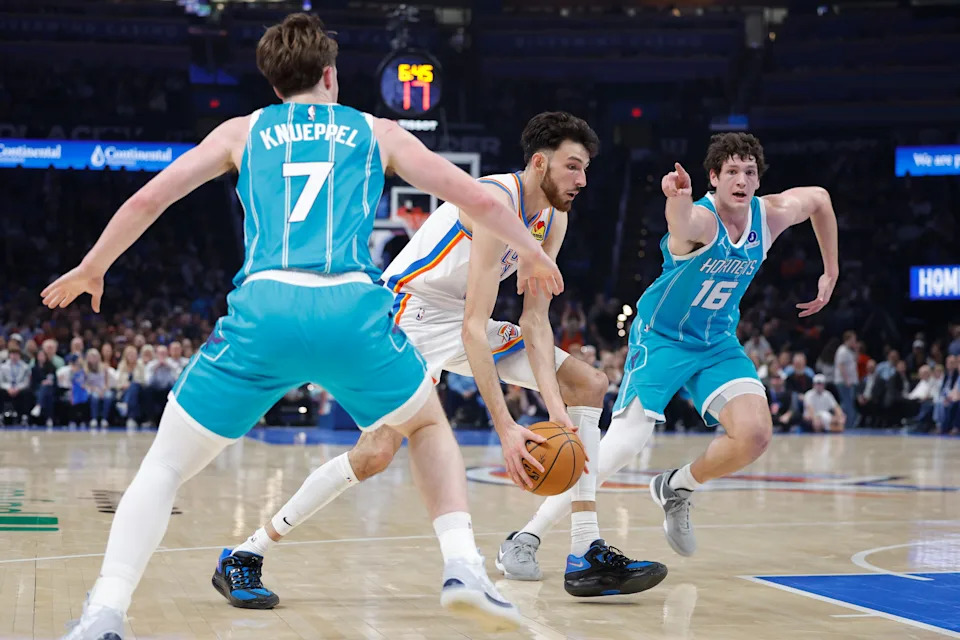 Jan 5, 2026; Oklahoma City, Oklahoma, USA; Oklahoma City Thunder center Chet Holmgren (7) drives between Charlotte Hornets guard Kon Knueppel (7) and Charlotte Hornets center PJ Hall (16) during the second quarter at Paycom Center. Mandatory Credit: Alonzo Adams-Imagn Images