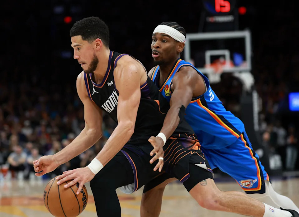 Jan 4, 2026; Phoenix, Arizona, USA; Phoenix Suns guard Devin Booker (1) drives to the basket against Oklahoma City Thunder guard Shai Gilgeous-Alexander (2) in the second half at Mortgage Matchup Center. Mandatory Credit: Mark J. Rebilas-Imagn Images