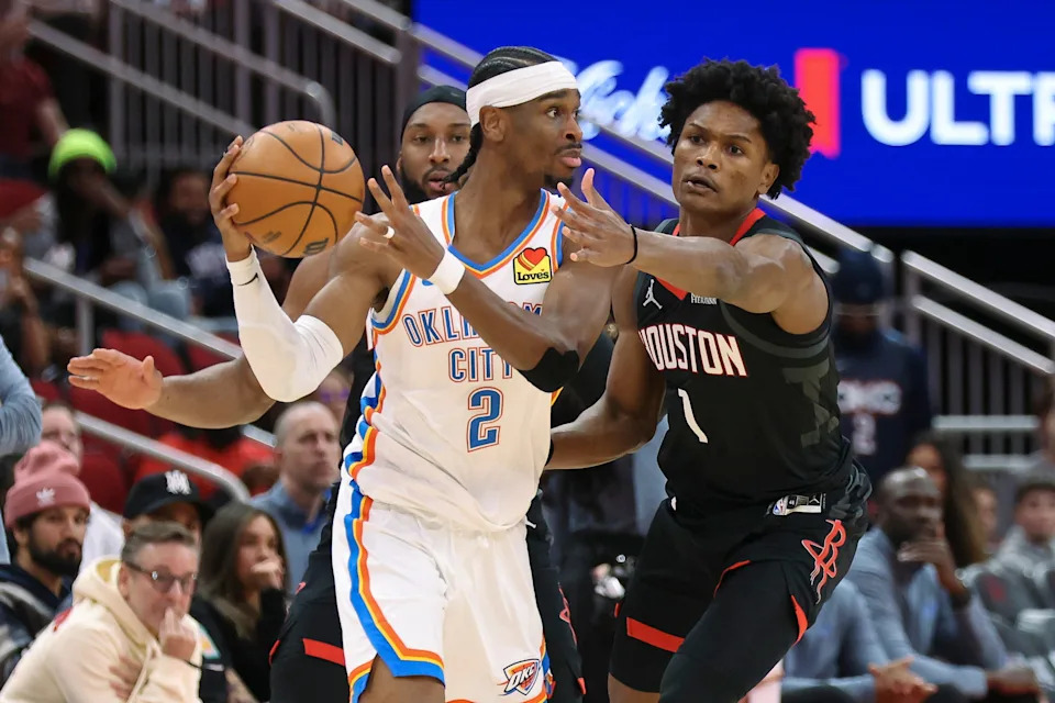 Jan 15, 2026; Houston, Texas, USA; Oklahoma City Thunder guard Shai Gilgeous-Alexander (2) looks to pass the ball as Houston Rockets guard Amen Thompson (1) defends during the first quarter at Toyota Center. Mandatory Credit: Troy Taormina-Imagn Images