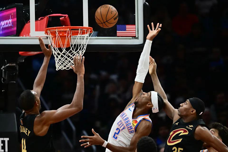 Jan 19, 2026; Cleveland, Ohio, USA; Oklahoma City Thunder guard Shai Gilgeous-Alexander (2) drives to the basket between Cleveland Cavaliers center Evan Mobley (4) and forward Nae'qwan Tomlin (35) during the second half at Rocket Arena. Mandatory Credit: Ken Blaze-Imagn Images