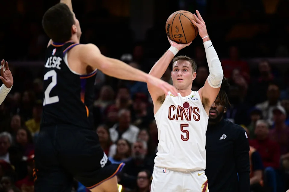 Cleveland Cavaliers guard Sam Merrill (5) shoots a 3-pointer as Phoenix Suns guard Collin Gillespie defends Dec. 31, 2025, in Cleveland.