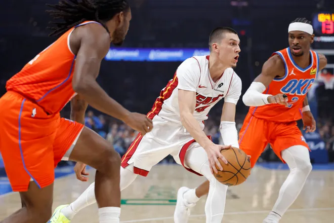 Jan 11, 2026; Oklahoma City, Oklahoma, USA; Miami Heat guard Tyler Herro (14) drives between Oklahoma City Thunder guard Cason Wallace (22) and guard Shai Gilgeous-Alexander (2) during the first quarter at Paycom Center. Mandatory Credit: Alonzo Adams-Imagn Images