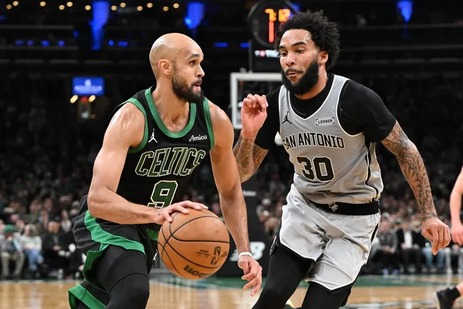 Jan 10, 2026; Boston, Massachusetts, USA; Boston Celtics guard Derrick White (9) drives to the basket against San Antonio Spurs forward Julian Champagne (30) during the second half at the TD Garden.