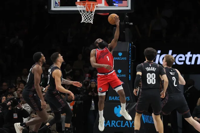 Jan 9, 2026; Brooklyn, New York, USA; Los Angeles Clippers guard James Harden (1) drives to the basket against Brooklyn Nets center Day'ron Sharpe (20) and forward Michael Porter Jr. (17) and guard Nolan Traore (88) and forward Danny Wolf (2) during the third quarter at Barclays Center.
