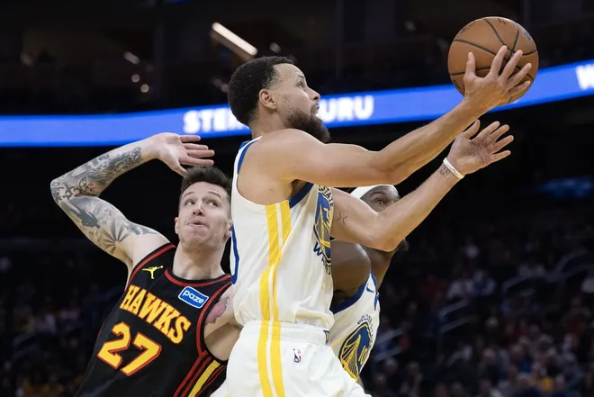Jan 11, 2026; San Francisco, California, USA; Golden State Warriors guard Stephen Curry (30) drives past Atlanta Hawks guard Vít Krejci (27) on a layup during the fourth quarter at Chase Center.