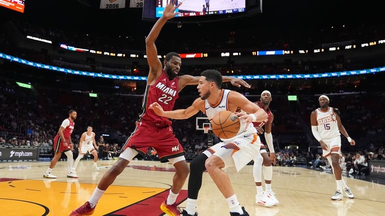 Phoenix Suns guard Devin Booker (1) drives forward defended by...