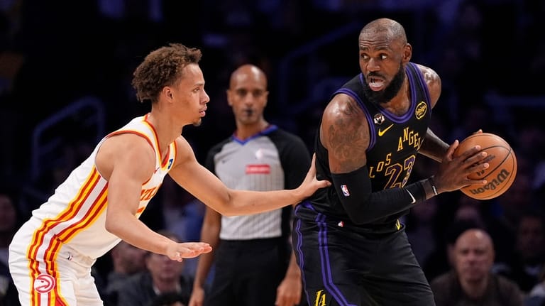 Los Angeles Lakers forward LeBron James, right, tries to get...