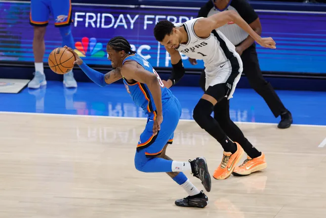 Jan 13, 2026; Oklahoma City, Oklahoma, USA; Oklahoma City Thunder guard/forward Jalen Williams (8) grabs a loose ball in front of San Antonio Spurs forward/center Victor Wembanyama (1) during the second half at Paycom Center. Mandatory Credit: Alonzo Adams-Imagn Images