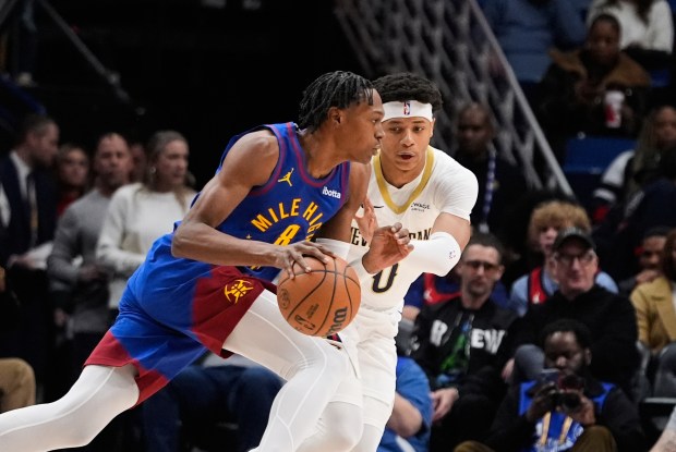 Denver Nuggets guard Peyton Watson (8) drives around New Orleans Pelicans guard Jeremiah Fears (0) in the first half of Tuesday's game in New Orleans. (AP Photo/Gerald Herbert)