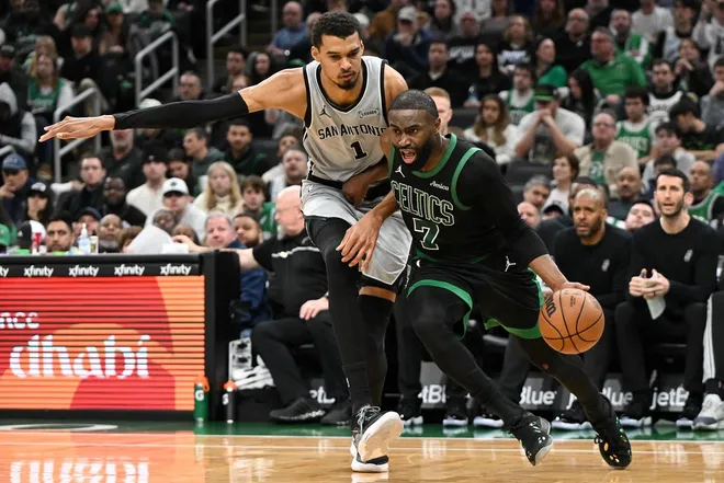 Jan 10, 2026; Boston, Massachusetts, USA; Boston Celtics guard Jaylen Brown (7) drives to the basket against San Antonio Spurs forward Victor Wembanyama (1) during the second half at the TD Garden.