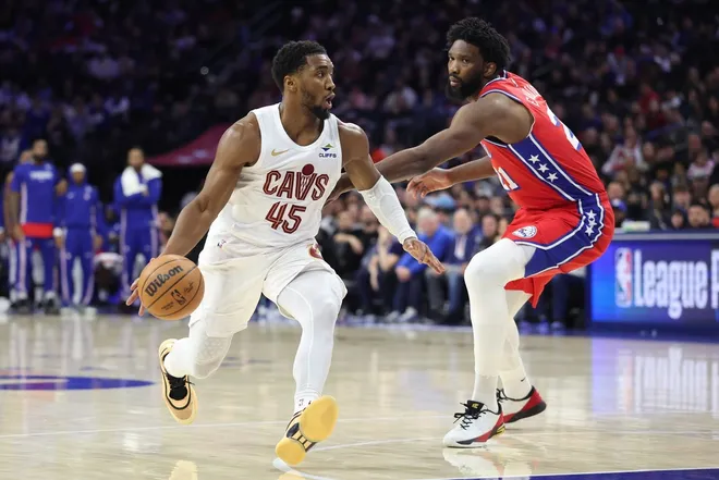 Jan 16, 2026; Philadelphia, Pennsylvania, USA; Cleveland Cavaliers guard Donovan Mitchell (45) drives against Philadelphia 76ers center Joel Embiid (21) during the fourth quarter at Xfinity Mobile Arena.
