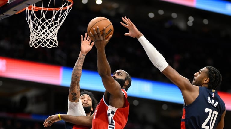Los Angeles Clippers guard James Harden, center, goes to the...