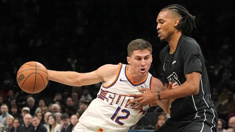 Brooklyn Nets' Ziaire Williams, right, defends Phoenix Suns' Collin Gillespie...