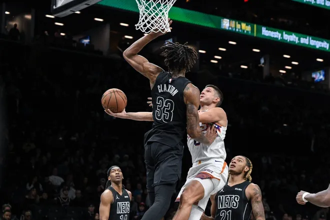 Jan 19, 2026; Brooklyn, New York, USA; Phoenix Suns guard Grayson Allen (8) shoots the ball against Brooklyn Nets center Nic Claxton (33) during the second half at Barclays Center.