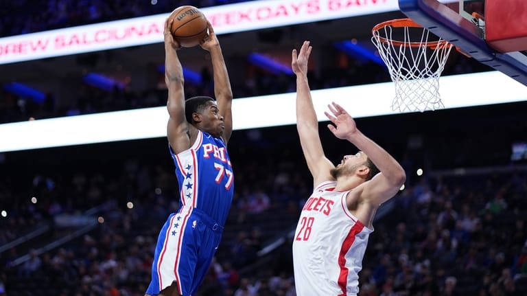 Philadelphia 76ers' VJ Edgecombe, left, goes up for a dunk...