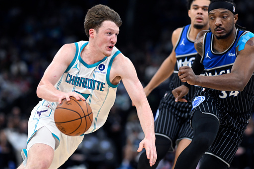 Charlotte Hornets guard Kon Knueppel, left, drives to the basket as Orlando Magic center Wendell Carter Jr., right, and forward Noah Penda, second from right, defend during the first half of an NBA basketball game, Thursday, Jan. 22, 2026, in Orlando, Fla. (AP Photo/Phelan M. Ebenhack)