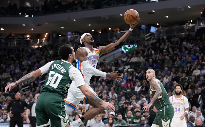 Jan 21, 2026; Milwaukee, Wisconsin, USA; Oklahoma City Thunder guard Shai Gilgeous-Alexander (2) drives to the basket against Milwaukee Bucks guard Cole Anthony (50) and m18/ in the first half at Fiserv Forum. Mandatory Credit: Michael McLoone-Imagn Images