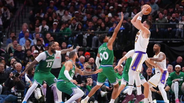 Los Angeles Lakers guard Luka Doncic, right, shoots against Dallas...