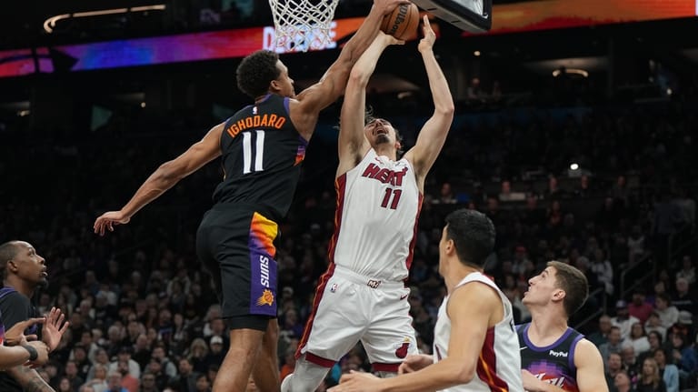 Phoenix Suns forward Oso Ighodaro, center left, blocks a shot...