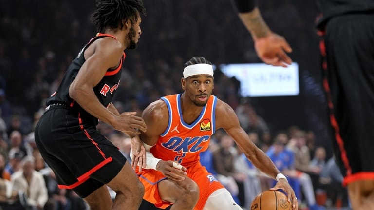 Oklahoma City Thunder guard Shai Gilgeous-Alexander, center, handles the ball...