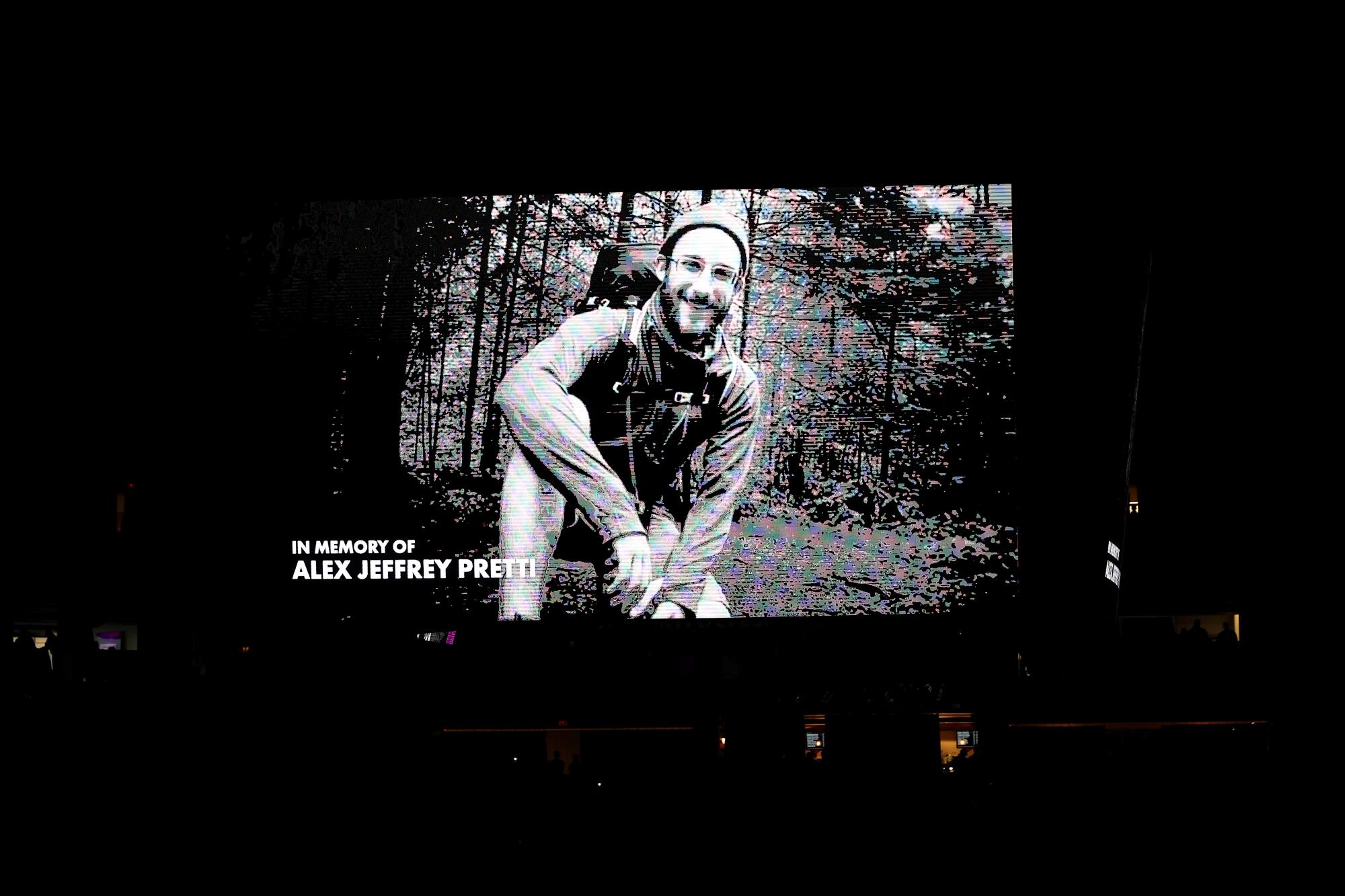 The video board shows a black and white photo of Alex Pretti