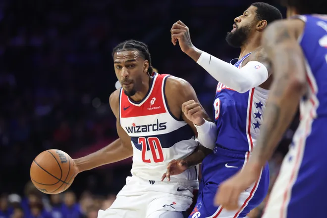 Washington Wizards center Alex Sarr (20) drives against Philadelphia 76ers forward Paul George (8) during the first quarter at Xfinity Mobile Arena in Philadelphia, Pennsylvania.