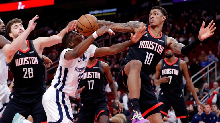 Memphis Grizzlies forward Cedric Coward, center, has his shot attempt...