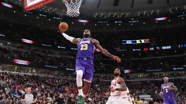 Los Angeles Lakers forward LeBron James, left, goes up for...