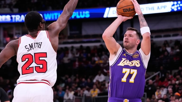 Los Angeles Lakers guard Luka Doncic, right, prepares to shoot...