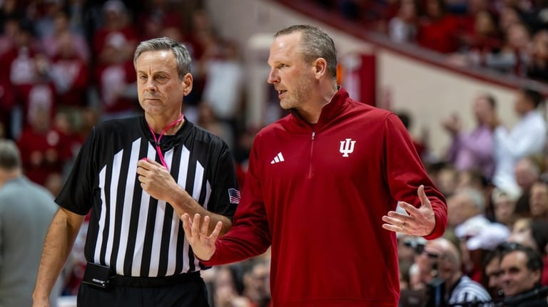 Indiana head coach Darian Devries talks with a game official...