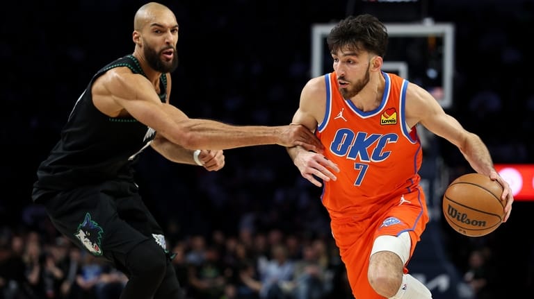 Oklahoma City Thunder center Chet Holmgren, right, works around Minnesota...