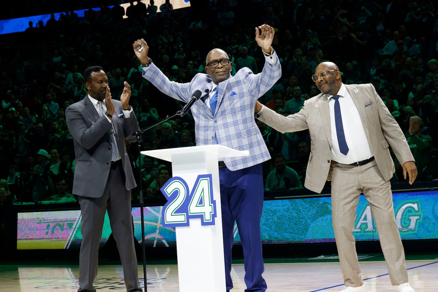 Former Dallas Mavericks Mark Aguirre, center, gestures as speaking before his jersey is...