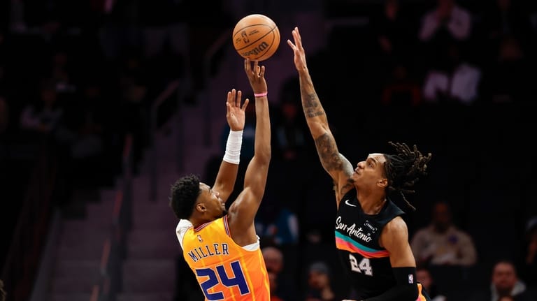 Charlotte Hornets forward Brandon Miller, left, shoots against San Antonio...