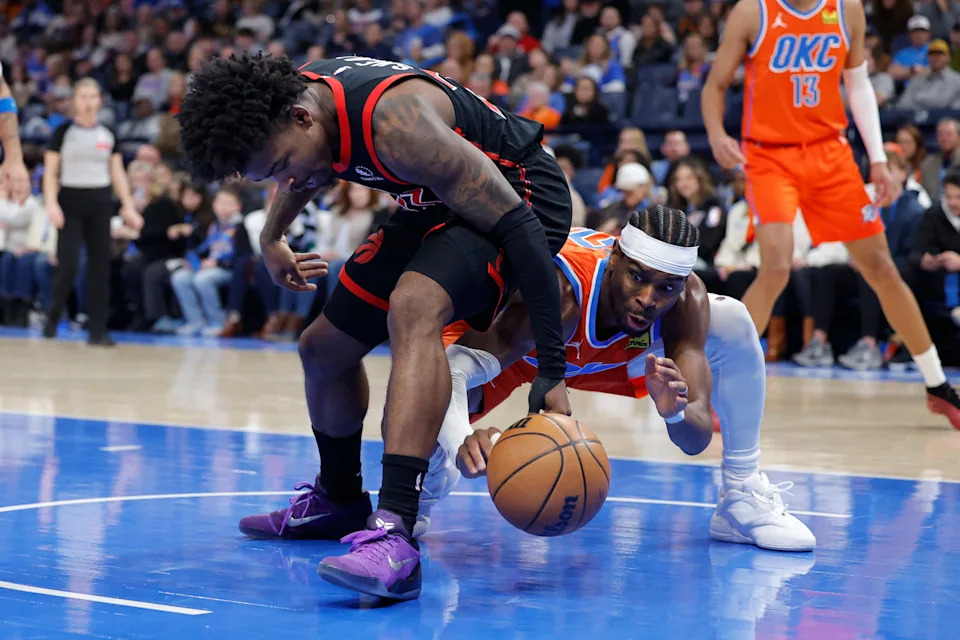 Jan 25, 2026; Oklahoma City, Oklahoma, USA; Toronto Raptors guard Jamal Shead (23) and Oklahoma City Thunder guard Shai Gilgeous-Alexander (2) fight for a loose ball during the second half at Paycom Center. Mandatory Credit: Alonzo Adams-Imagn Images