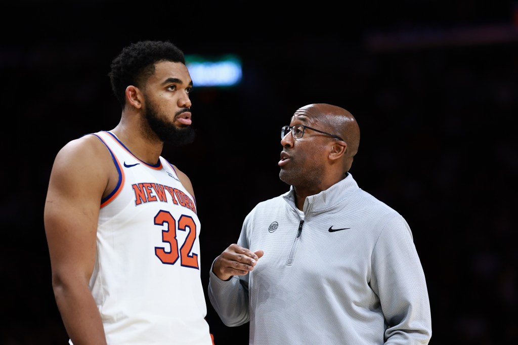 Karl-Anthony Towns #32 of the New York Knicks speaks with head coach Mike Brown during the second half against the Miami Heat at Kaseya Center on October 26, 2025 in Miami, Florida.