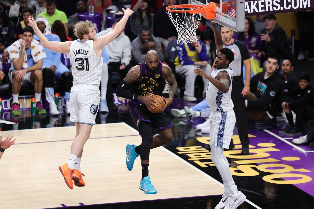 #23 SF LeBron James of the Los Angeles Lakers drives between two defenders during an NBA game against the Memphis Grizzlies on January 2, 2026 in Los Angeles, CA.