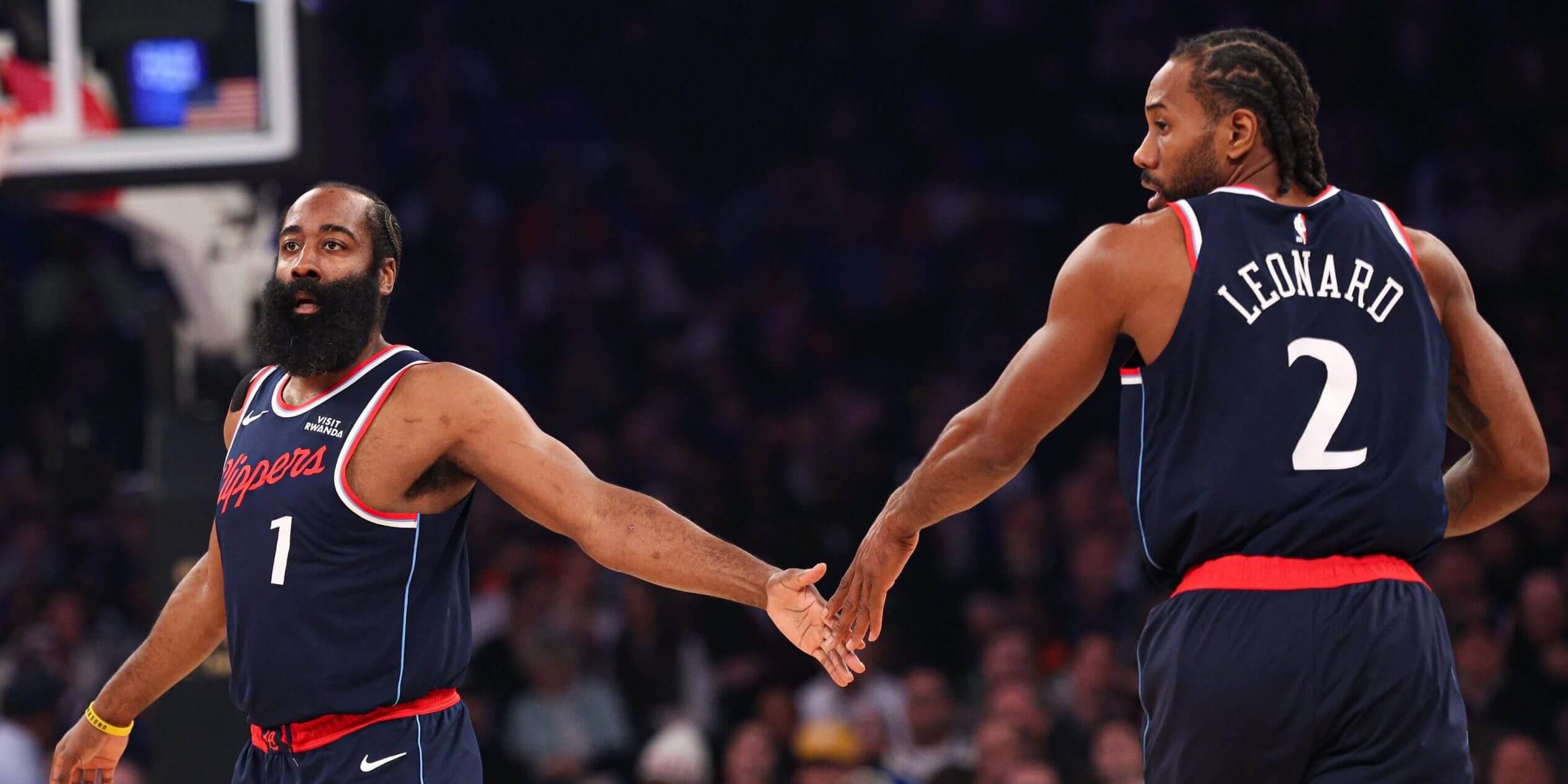 A photo of James Harden and Kawhi Leonard giving each other a five. 