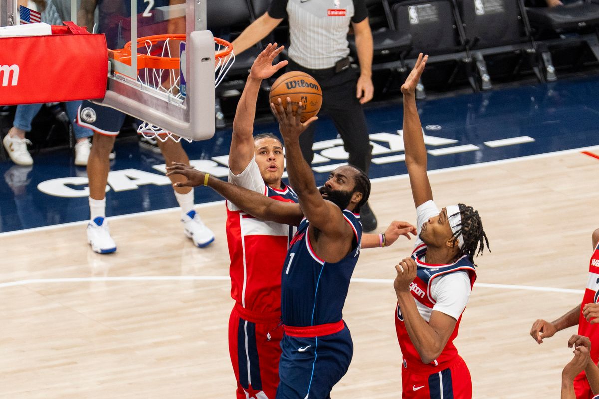 Los Angeles Clippers guard James Harden (1) scores the layup over two defenders during an NBA basketball game against the Washington Wizards, Wednesday January 14th, 2026 in Los Angeles, California.