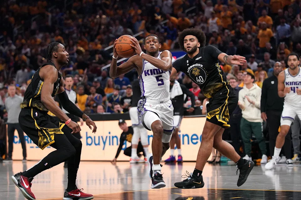 Apr 20, 2023; San Francisco, California, USA; Sacramento Kings guard De'Aaron Fox (5) drives to the hoop between Golden State Warriors forward Jonathan Kuminga (00) and forward Anthony Lamb (40) in the second quarter during game three of the 2023 NBA playoffs at the Chase Center. Mandatory Credit: Cary Edmondson-USA TODAY Sports