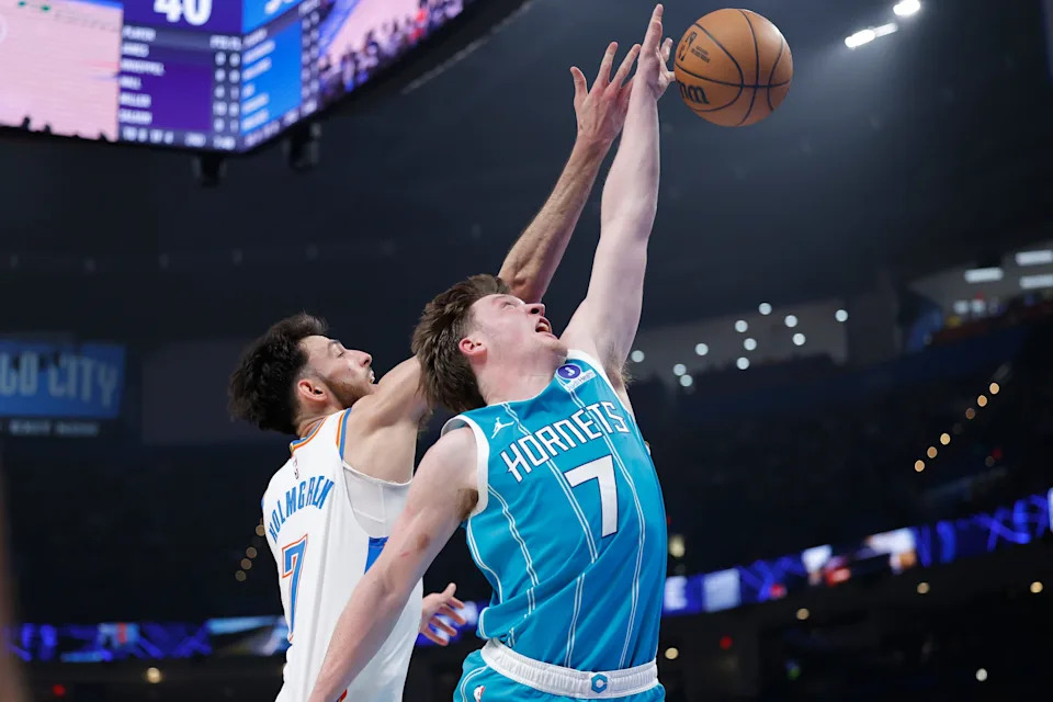 Jan 5, 2026; Oklahoma City, Oklahoma, USA; Oklahoma City Thunder center Chet Holmgren (7) and Charlotte Hornets guard Kon Knueppel (7) reach for a rebound during the second quarter at Paycom Center. Mandatory Credit: Alonzo Adams-Imagn Images