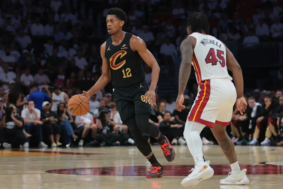 Apr 26, 2025; Miami, Florida, USA; Cleveland Cavaliers forward De'Andre Hunter (12) dribbles the basketball as Miami Heat guard Davion Mitchell (45) defends in the first quarter during game three for the first round of the 2025 NBA Playoffs at Kaseya Center. Mandatory Credit: Sam Navarro-Imagn Images