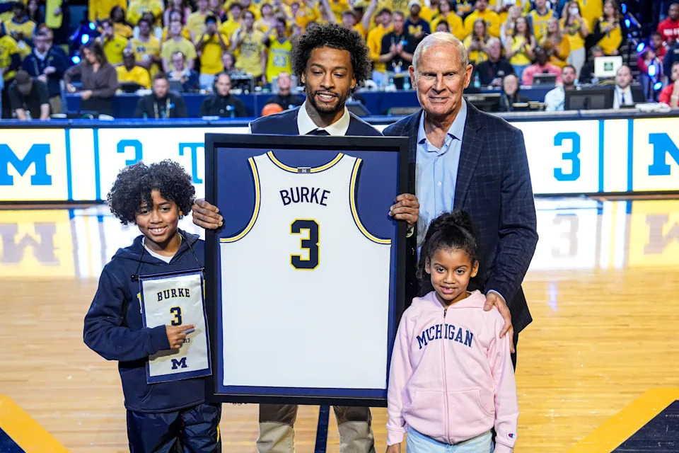Trey Burke and former Michigan head coach John Beilein pose for a photo during his jersey retirement ceremony at Crisler Center in Ann Arbor on Friday, Jan. 23, 2026.
