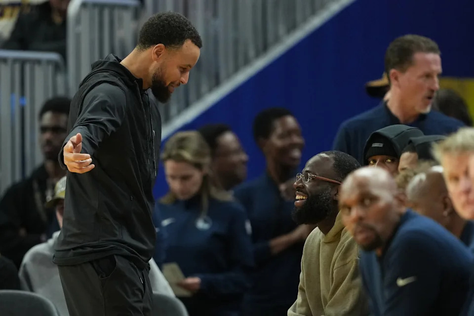 Jan 2, 2026; San Francisco, California, USA; Golden State Warriors guard Stephen Curry (left) talks with forward Draymond Green (center right) during the third quarter against the Oklahoma City Thunder at Chase Center. Mandatory Credit: Darren Yamashita-Imagn Images