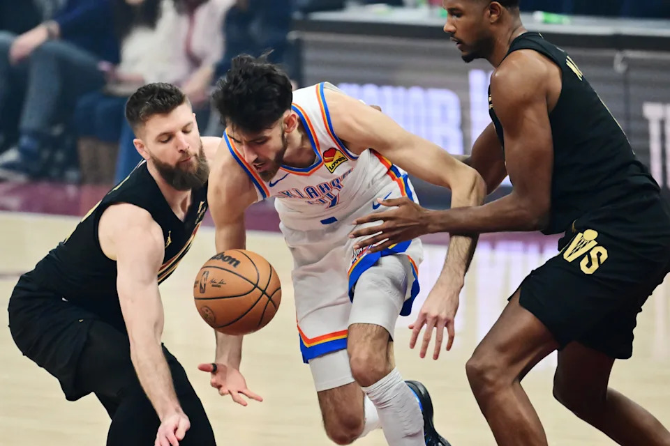 Jan 19, 2026; Cleveland, Ohio, USA; Oklahoma City Thunder center Chet Holmgren (7) drives to the basket between Cleveland Cavaliers forward Dean Wade (32) and center Evan Mobley (4) during the first quarter at Rocket Arena. Mandatory Credit: Ken Blaze-Imagn Images