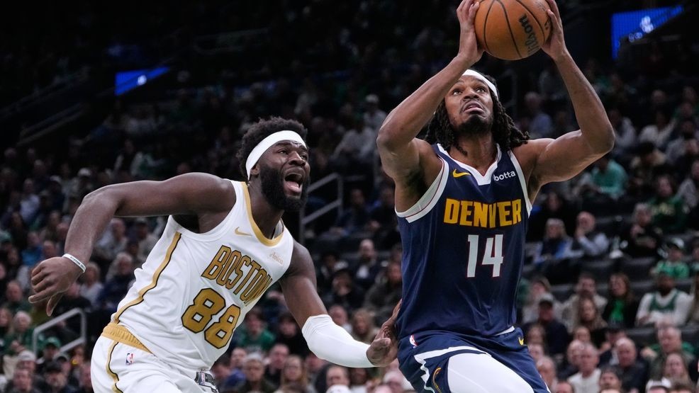 Denver Nuggets forward Daron Holmes II (14) drives to the basket past Boston Celtics center Neemias Queta (88) during the first half of an NBA basketball game, Wednesday, Jan. 7, 2026, in Boston. (AP Photo/Charles Krupa)